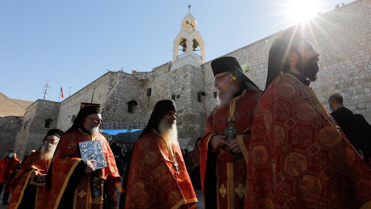 Miembros del clero se reúnen a la llegada del Patriarca Griego Ortodoxo de Jerusalem Theophilos III a la Iglesia de la Natividad para celebrar la Navidad según el calendario Ortodoxo Oriental en Belén, en la Cisjordania ocupada, el 6 de enero de 2022.