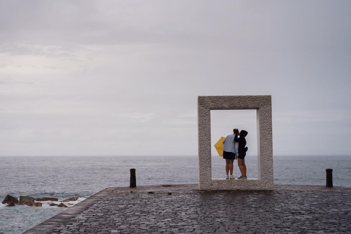 Una pareja se besa este domingo en la costa del municipio de Garachico, en el norte de Tenerife.