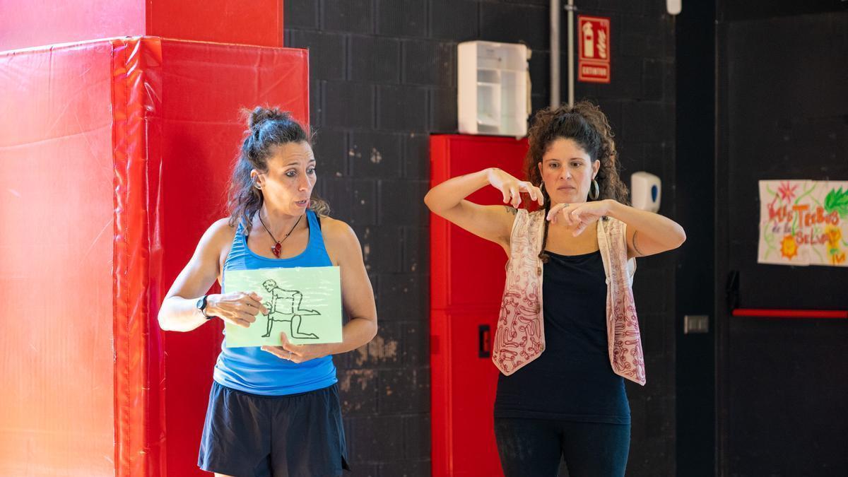 Una monitora explica l’activitat en llengua de signes durant un taller de circ.