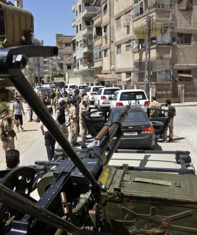 Militares sirios escoltan vehículos de la OTAN.