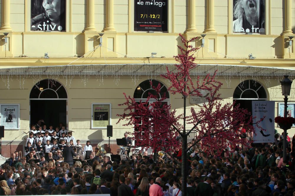 Mil niños de la Fundación Victoria, la Banda Municipal de Málaga y la Escolanía del Corpus Christi ofrecen un concierto navideño frente al teatro malagueño.