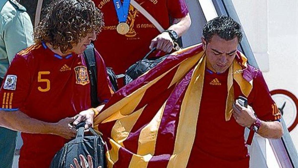 Abanderados 8 Puyol y Xavi bajan del avión en Barajas con la senyera.