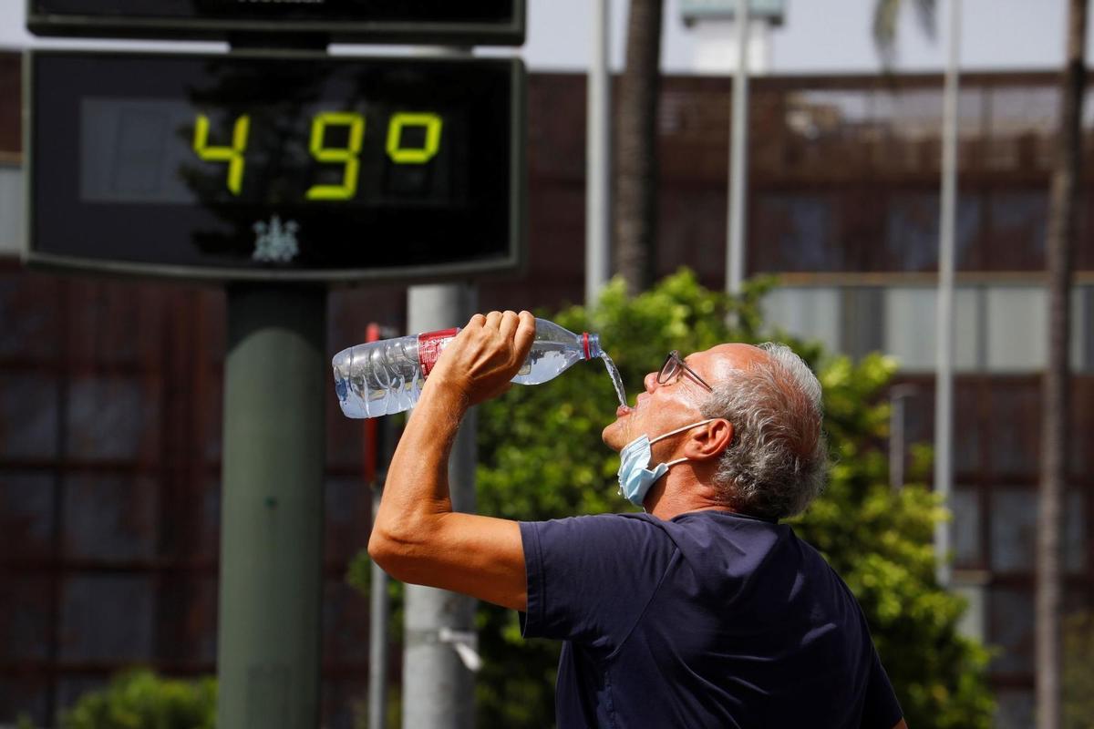 Un hombre bebe agua en Córdoba durante una ola de calor.