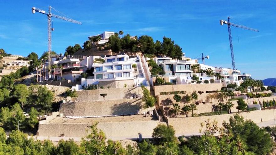 Ladera de Pedramala (es la urbanización Racó de Galeno) en la que se alzan modernos chalés y numerosas grúas.