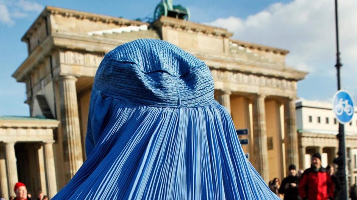 Una mujer, con burka, frente a la puerta de Brandeburgo, en Berlín.