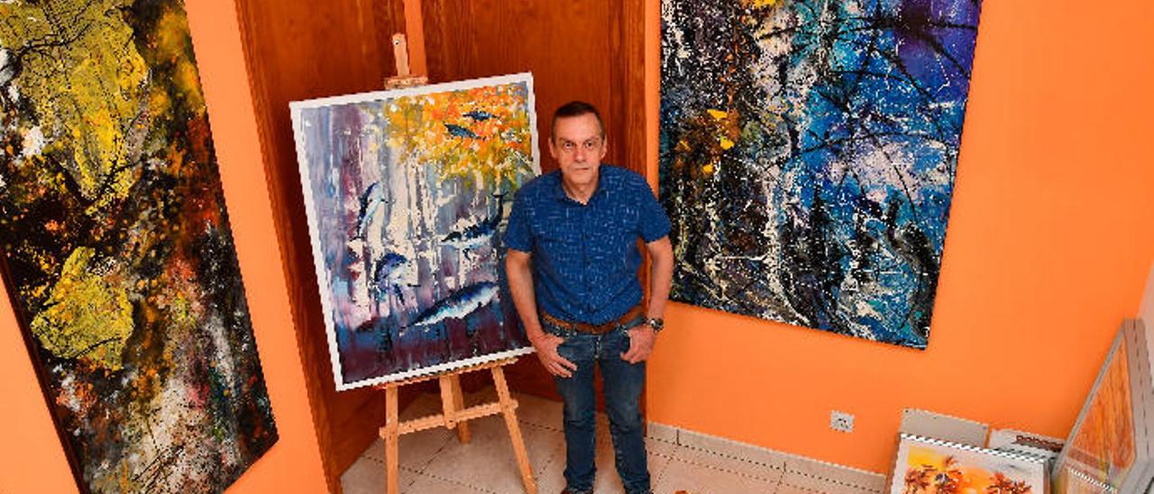 El odontólogo Carlos Strólogo, en su domilicio, entre varios cuadros abstractos y mixtos que ha pintado.