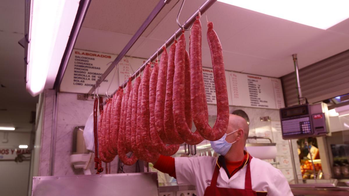 Un empleado del Mercado París coloca las longanizas en el Jueves Lardero del año pasado