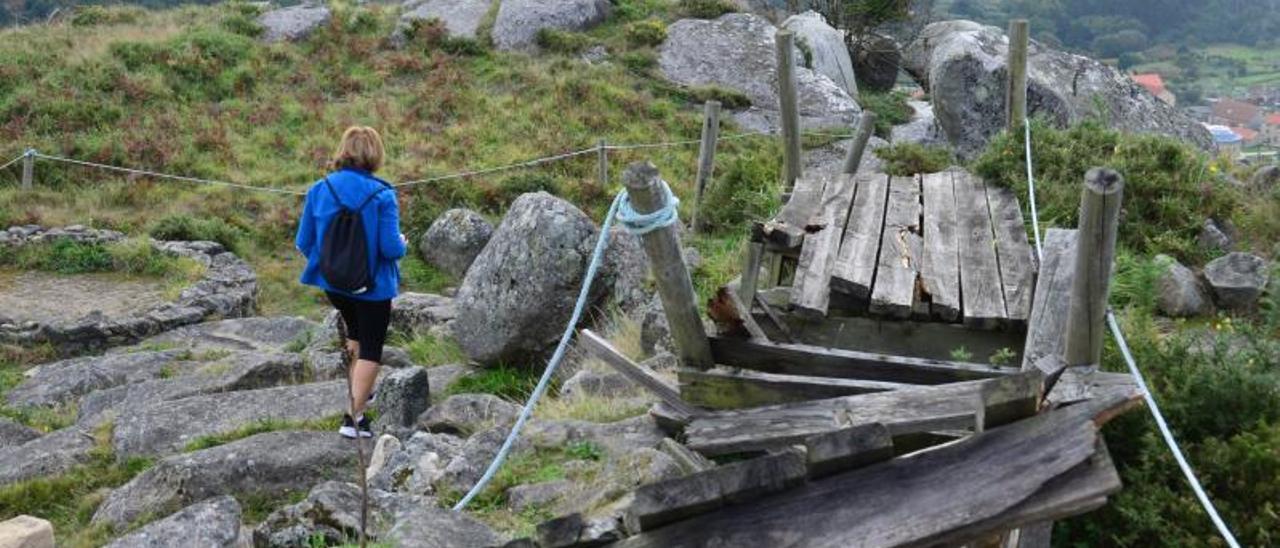 Una visitante de O Facho, el sábado, ante una de las pasarelas de madera del área arqueológica.   | // G.NÚÑEZ