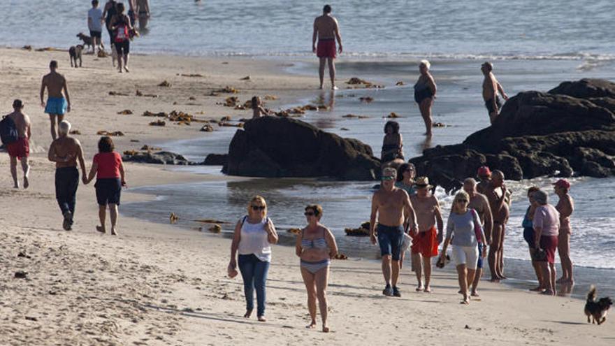 Bañistas pasean por una playa de Vigo // EFE/Salvador Sas