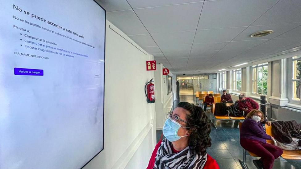 Una mujer observa una pantalla fuera de servicio en uno de los pasillos del Clínic, durante el ciberataque.