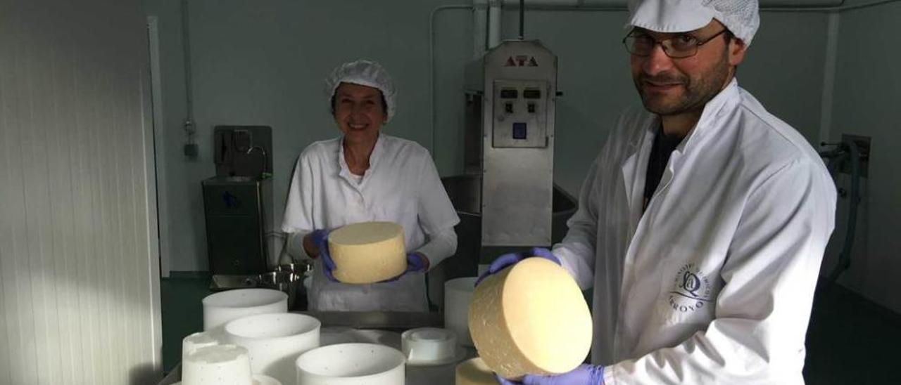 Ana Posada y Alberto Valiente desmoldan quesos en su nave de Moruxones, en Piloña, ayer.