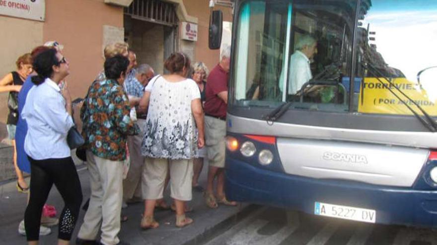 El transporte gratuito une las más de cien urbanizaciones con el centro de la ciudad. A la derecha, la parada del Hotel Fontana con el hito de información estropeado.