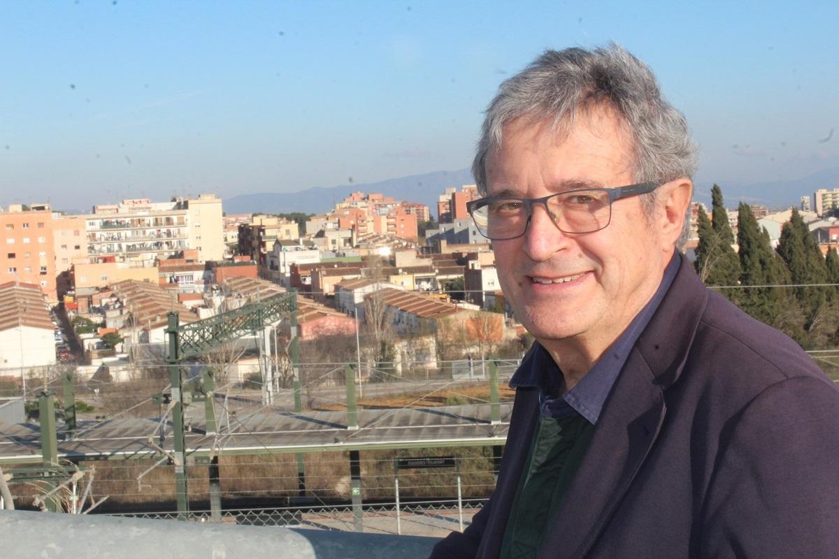 Joan Armangué fotografiat davant de  l’estació de l’AVE i els barris del sector oest de Figueres