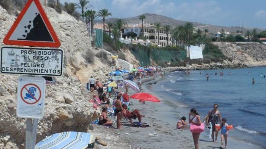 Imagen de esta semana de la playa de l´Almadrava, con decenas de bañistas en la zona prohibida bajo el talud más cercano a La Illeta.