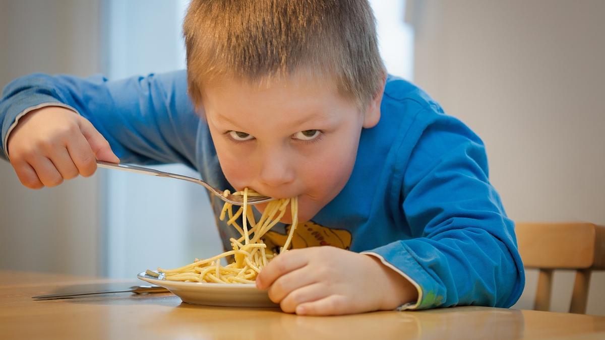 Un niño se come un plato de espaguetis