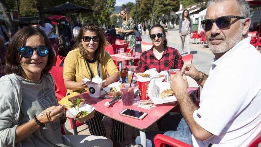 Carmen Salinas, Lola Salinas, Verónica Pérez y Pablo Salinas, ayer, en el Bombé. Abajo, las terrazas de las casetas del paseo, abarrotadas.