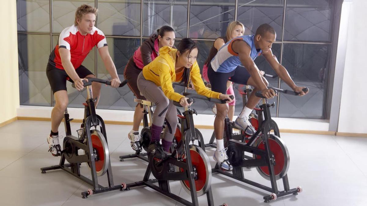Gente en las bicicletas estáticas del gimnasio