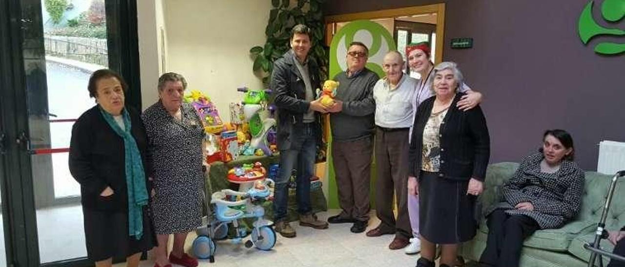 Nicolás González e internos de Geriatros, con juguetes donados.