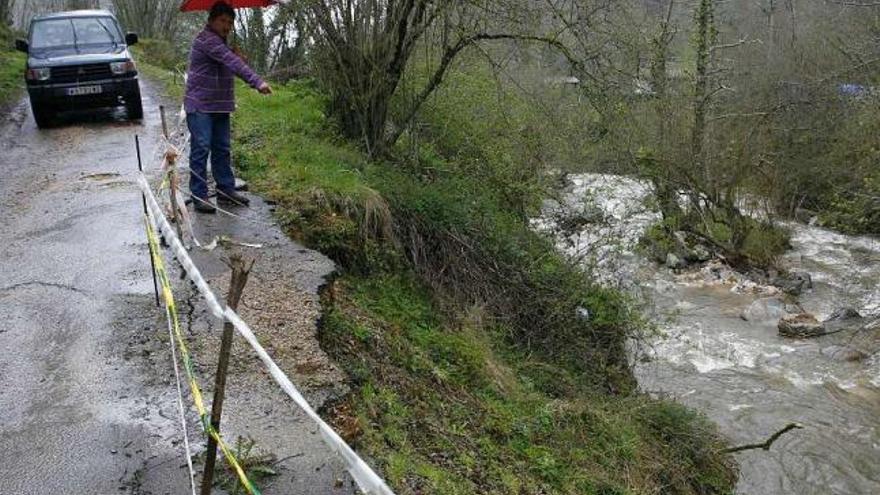 Norberto Álvarez señala uno de los argayos de la carretera a La Pesanca.