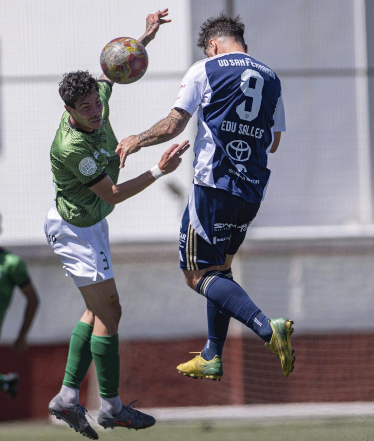 Edu Salles, del San Fernando, remata de cabeza ante un rival, ayer