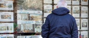 Una persona observa los anuncios del escaparate de una inmobiliaria de Vigo.
