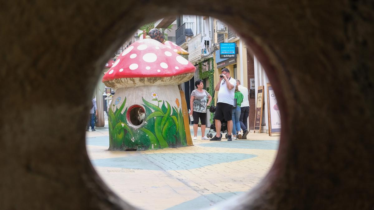 Un turista toma una foto de una seta de la calle San Francisco con la pintura levantada.