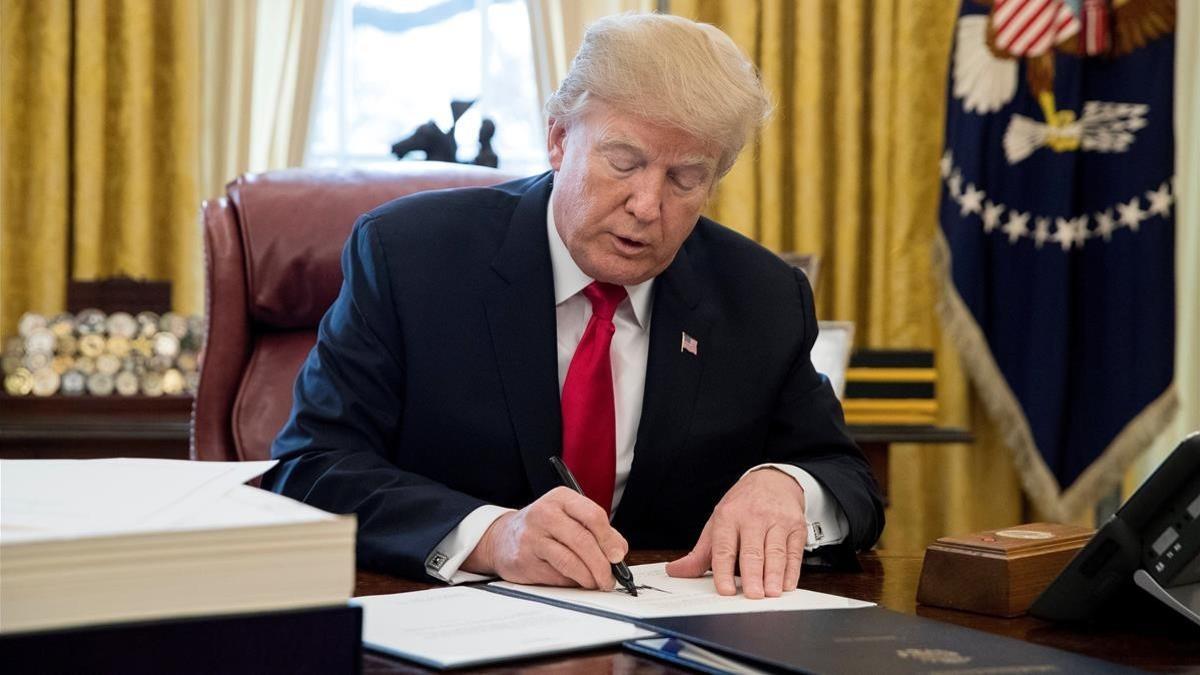 Trump firma la ley sobre la reforma fiscal, en el Despacho Oval de la Casa Blanca, en Washington, el 22 de diciembre.