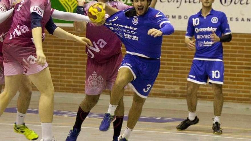 Juan Echevarría, con el balón, sujetado por un rival.