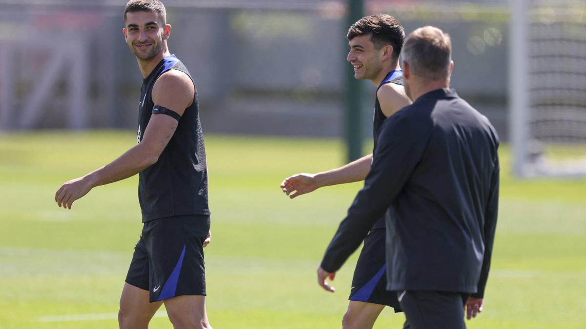 Ferran Torres y Pedri entran al campo de entrenamiento seguidos por Hansi Flick.