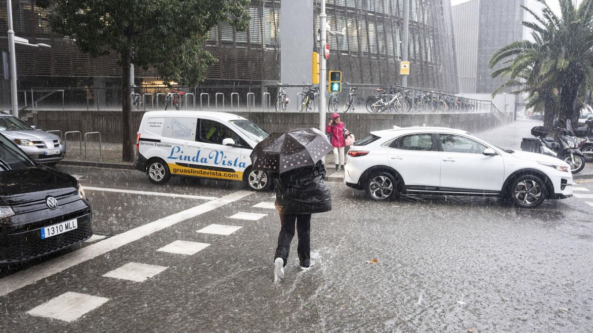 Individuo cruzando una calzada inundada en Barcelona.