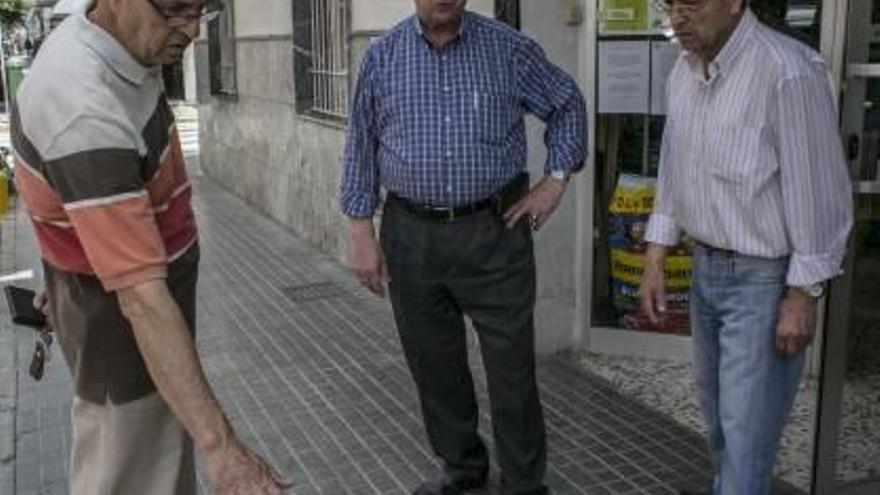 Vecinos, con el alcalde pedáneo José Tarí en el centro, mostrando la altura de los perros.