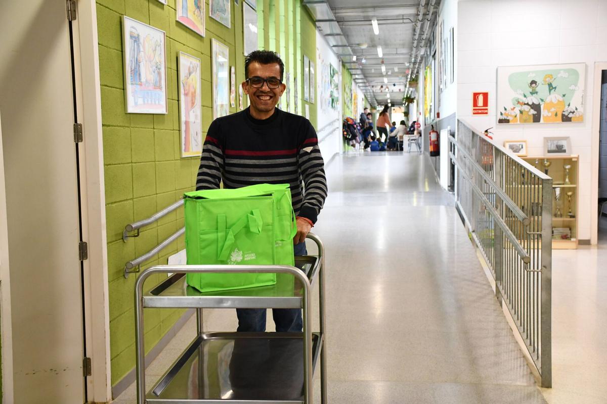 Santi, ordenanza del colegio Rossend Montané, de Sant Pere Molanta (Alt Penedès), reparte los tápers, metidos en bolsas térmicas, con la comida sobrante del comedor escolar.