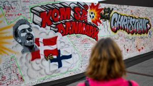 Una persona observa el mural pintado en Copenhague con mensajes escritos por la afición danesa.