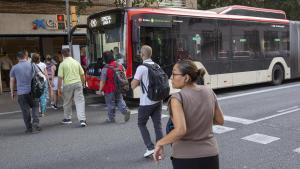 Usuarios del bus alternativo por el corte de la L5 caminan desde la parada de Collblanc para subir en uno de los vehículos.