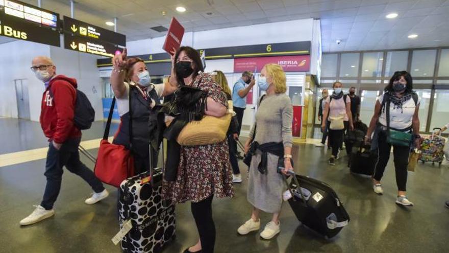 Una trabajadora de la compañía aérea indicando donde ir a los turistas. | | ANDRÉS CRUZ