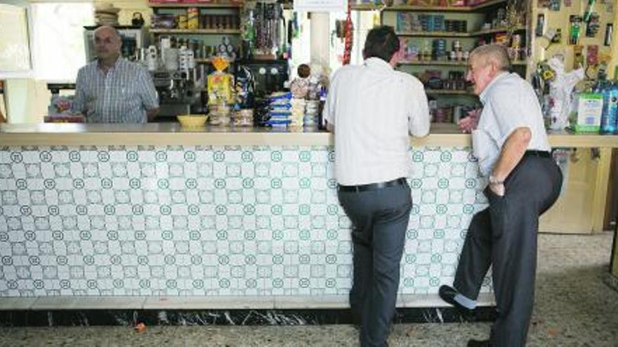 Miguel Ángel Riesgo y su esposa, Alicia Álvarez, tras el mostrador de su bar tienda. / ignacio pulido