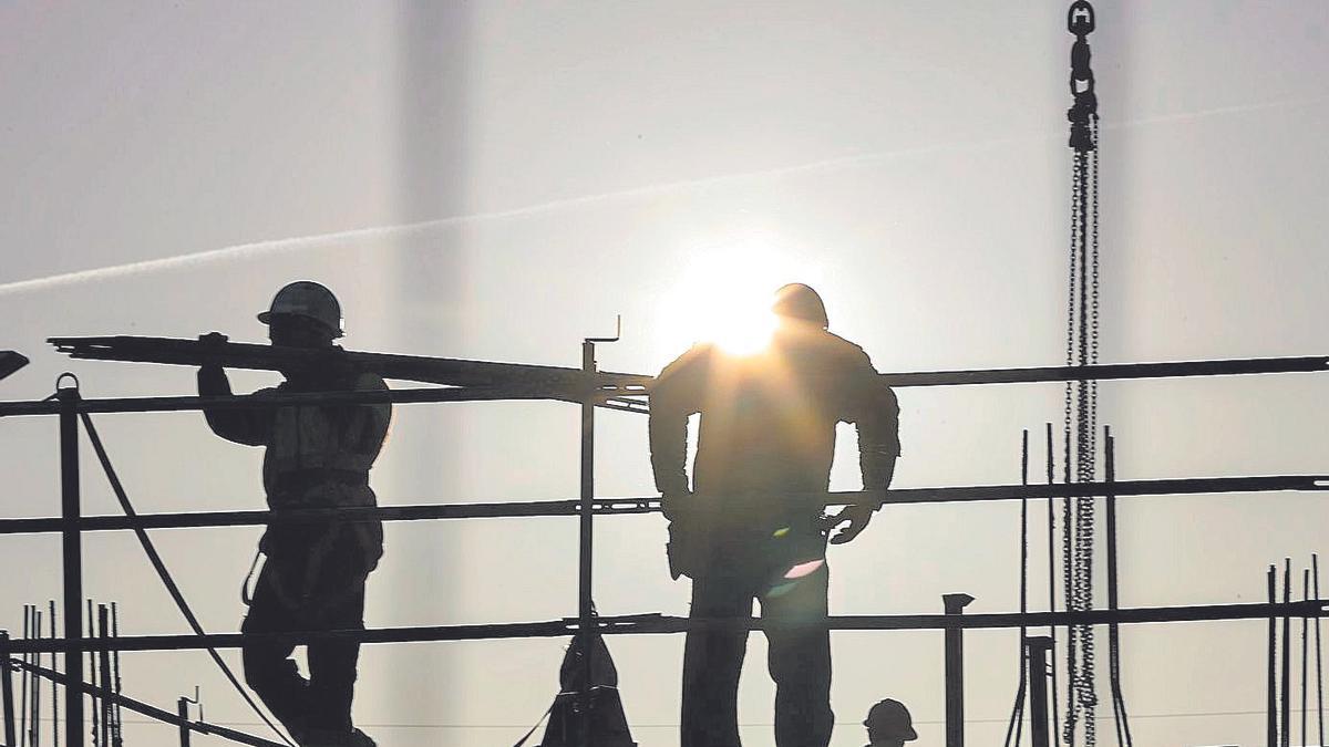 Dos trabajadores de la construcción, en un edificio.
