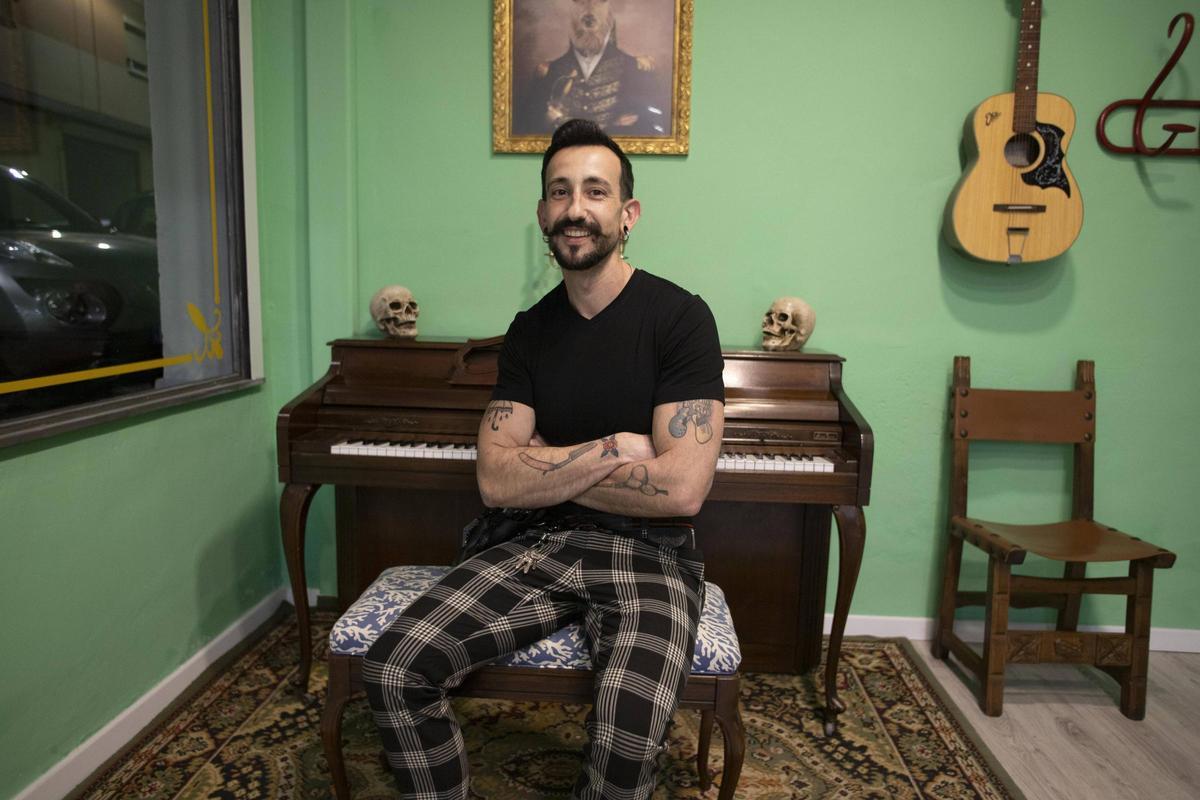 Sergio Martos, en la barbería que acaba de abrir en Xàtiva, con un piano y una guitarra como elementos decorativos.