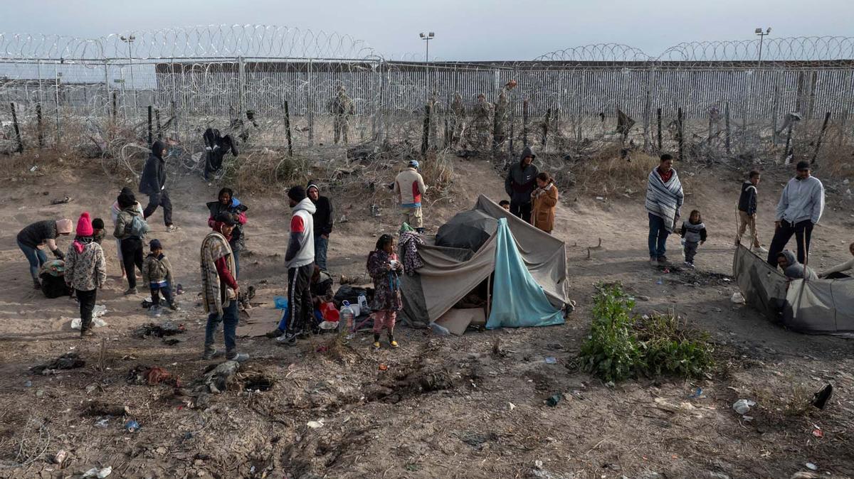 Migrantes acampan a lo largo de la orilla del río Grande mientras esperan entregarse a las autoridades de inmigración en El Paso, Texas, EE.UU