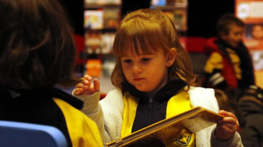 Primer pla d&#039;una nena mirant un llibre.