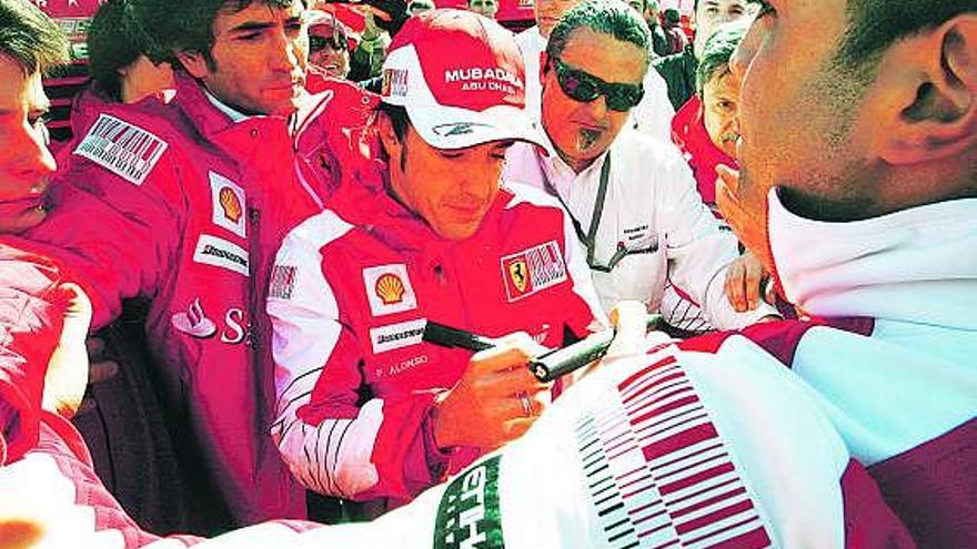 Fernando Alonso firma autógrafos en Montmeló durante las pruebas realizadas en pretemporada.