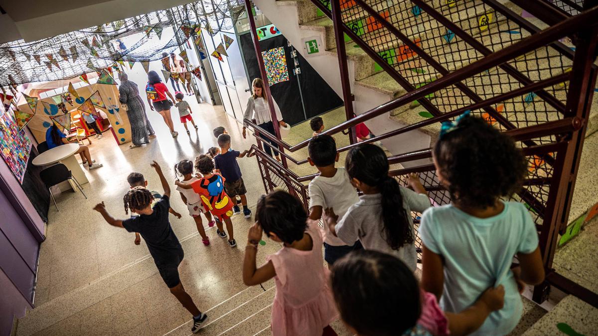 Un grupo de niños baja las escaleras de la escuela Lola Anglada de L'Hospitalet.