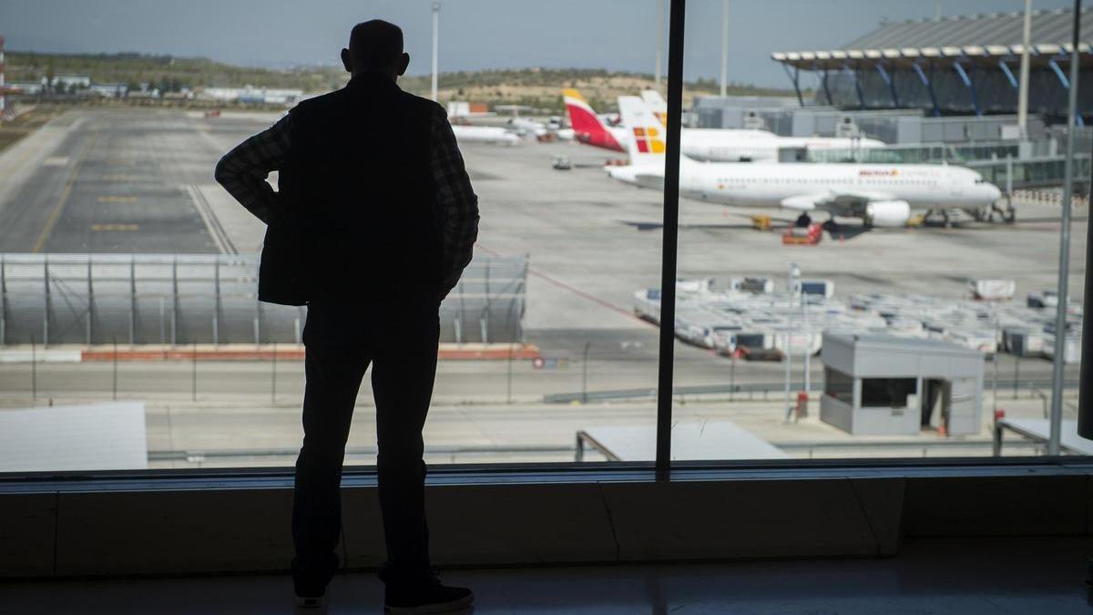 Un hombre observa aviones en un aeropuerto.