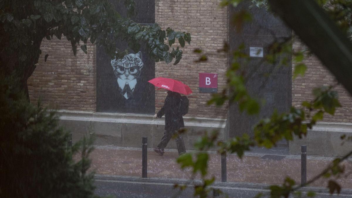 Una mujer se protege de la intensa lluvia en Murcia en una imagen de archivo