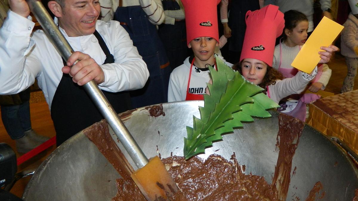 Los niños aportan sus piezas para que el maestro chocolatero las derrita.