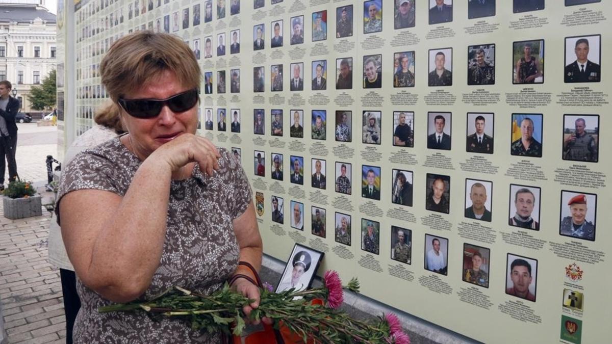 Una mujer llora junto al memorial a las víctimas de la revolución.