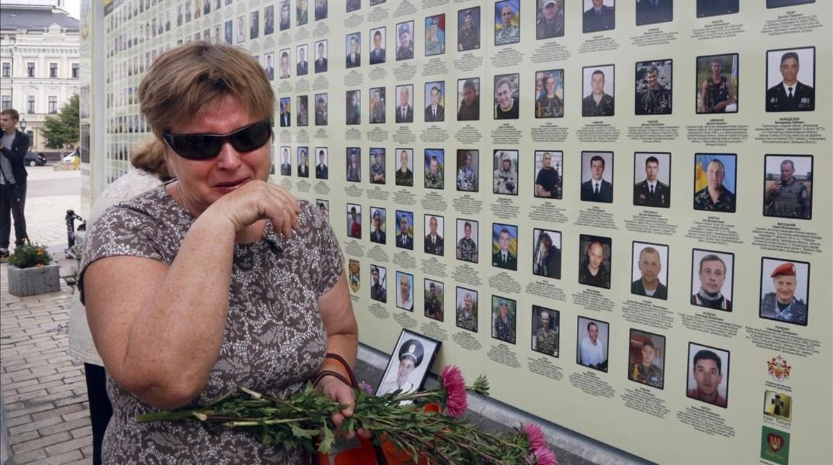 zentauroepp39842148 a woman cries at a memorial wall with photos of servicemen k170908142015