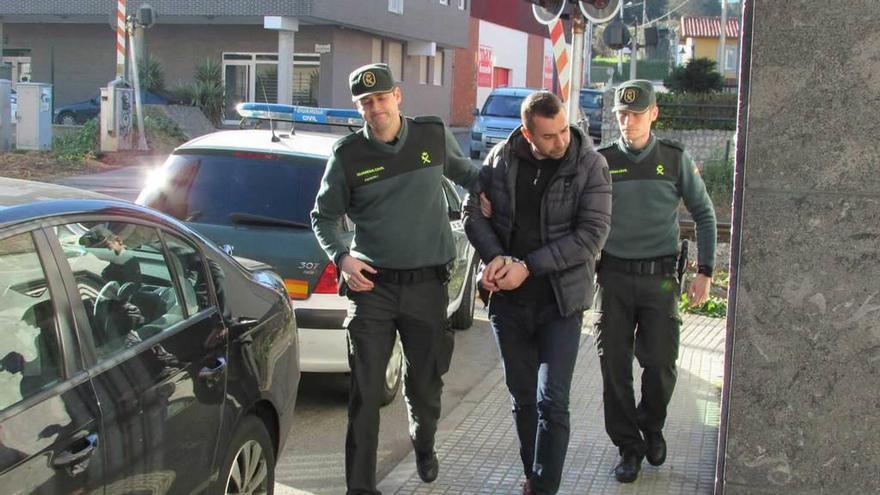 N. I., entrando ayer en el Juzgado de Llanes custodiado por dos agentes de la Guardia Civil.