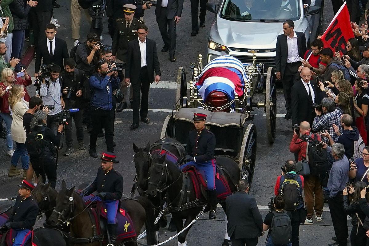 The funeral cortege of Uruguays former president, Jose Pepe Mujica, makes its way through the capital, Montevideo,on May 14, 2025, a day after his death. Mujica, an ex-guerrilla fighter and hero of the Latin American left, died on May 13, 2025 at the age of 89. The humble leader -- who once spent a dozen years behind bars for revolutionary activity -- lost his battle against cancer after announcing in January the disease had spread and he would stop treatment. (Photo by Mariana MENDEZ / AFP)