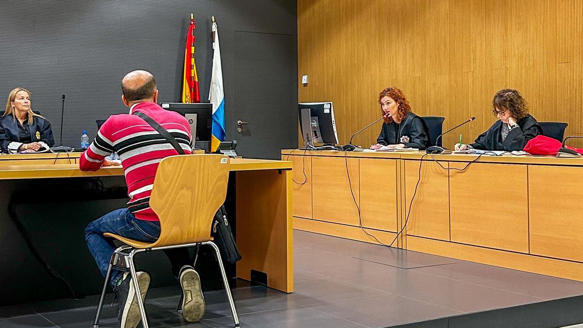 El acusado, de espaldas, responde a las preguntas de la fiscal en el juicio.